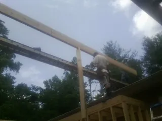 Carpenter setting a ridge beam over a new addition frame — Ice Dam Removal by Roofing Brothers in Strawberry Point