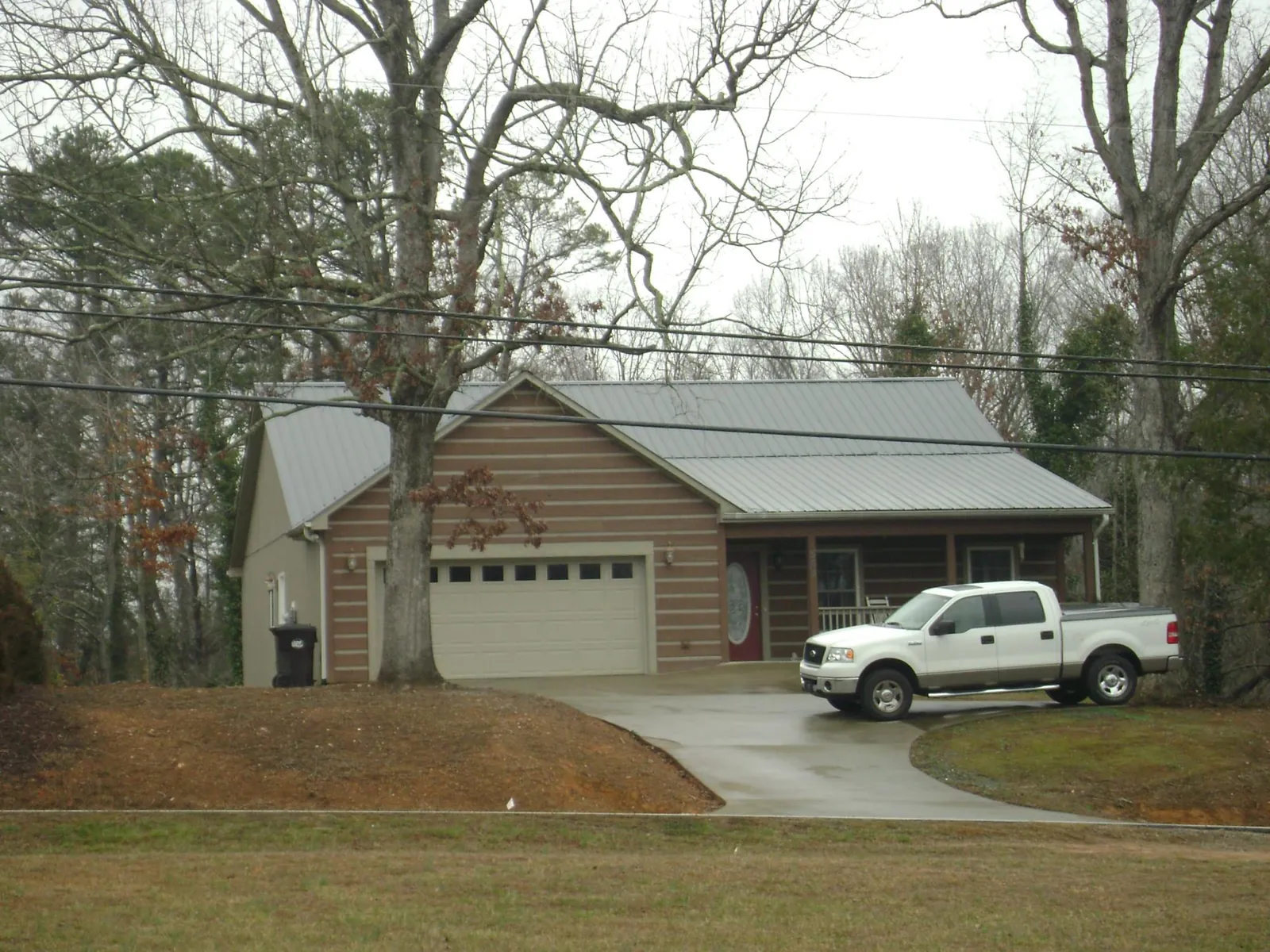 Gray metal roof on a log sided house with an attached two car garage in Strawberry Point